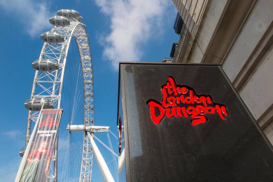 El letrero del London Dungeon y una noria.