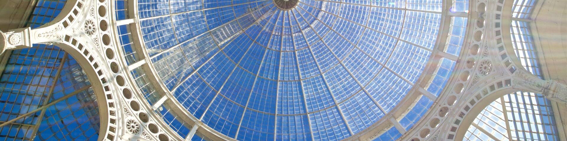 Una gran cúpula circular de vidrio con intrincada estructura metálica.