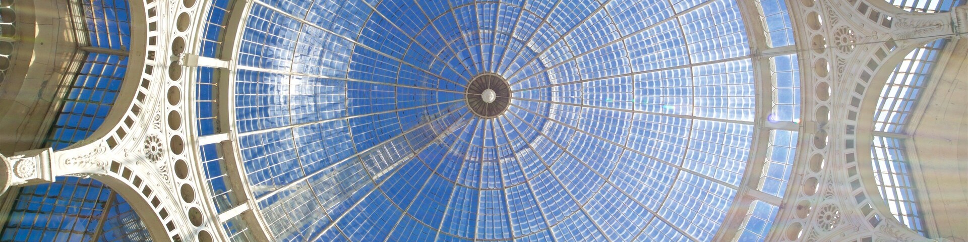 Uma grande cúpula circular de vidro com estrutura metálica detalhada.
