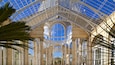 A grand glass-domed structure with ornate columns and arches.
