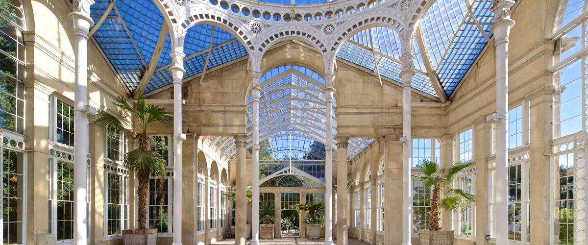 A grand glass-domed structure with ornate columns and large windows.