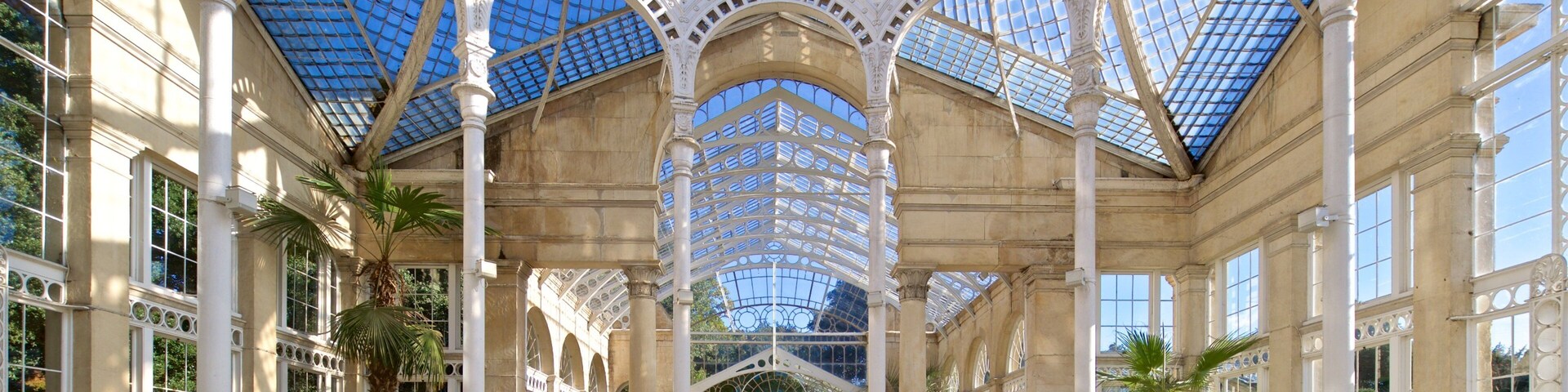 A grand glass-domed structure with ornate columns and large windows.