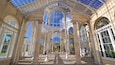A grand glass-domed structure with ornate columns and large windows.