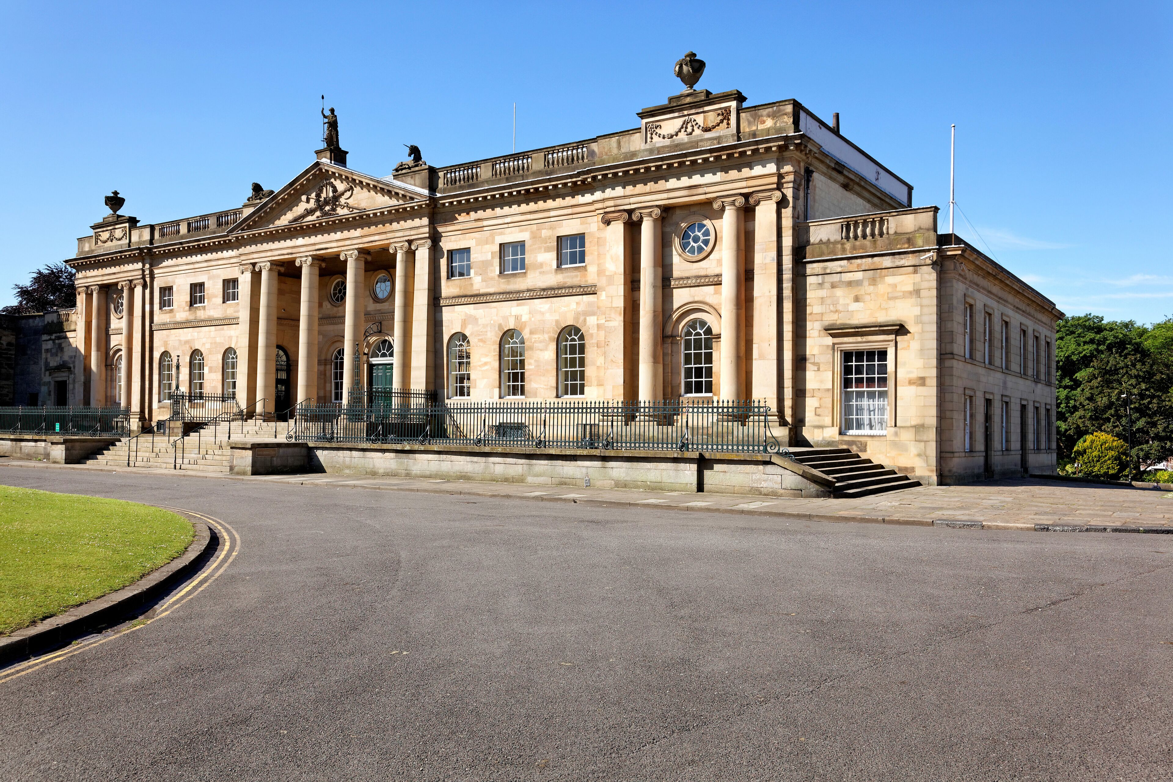 A large, historic building with classical architecture, including columns and a clock tower.