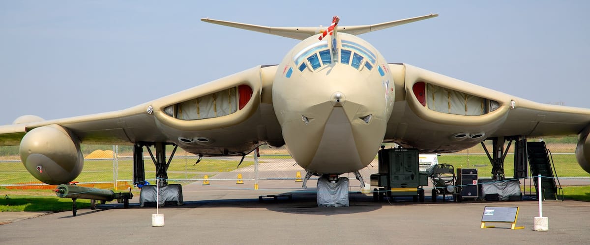 A military aircraft parked on a tarmac with a clear sky in the background.