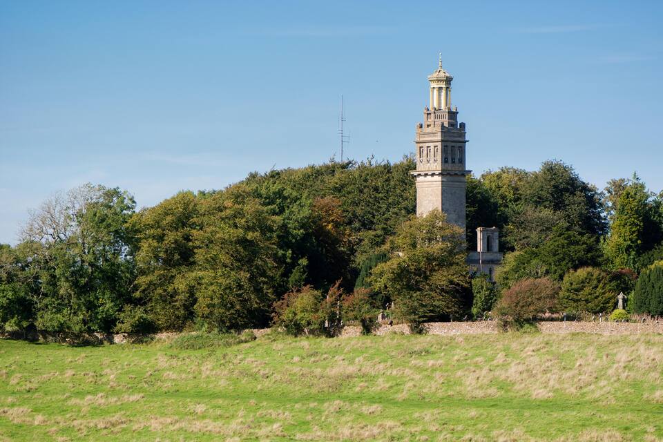 Een toren omringd door bomen en gras.