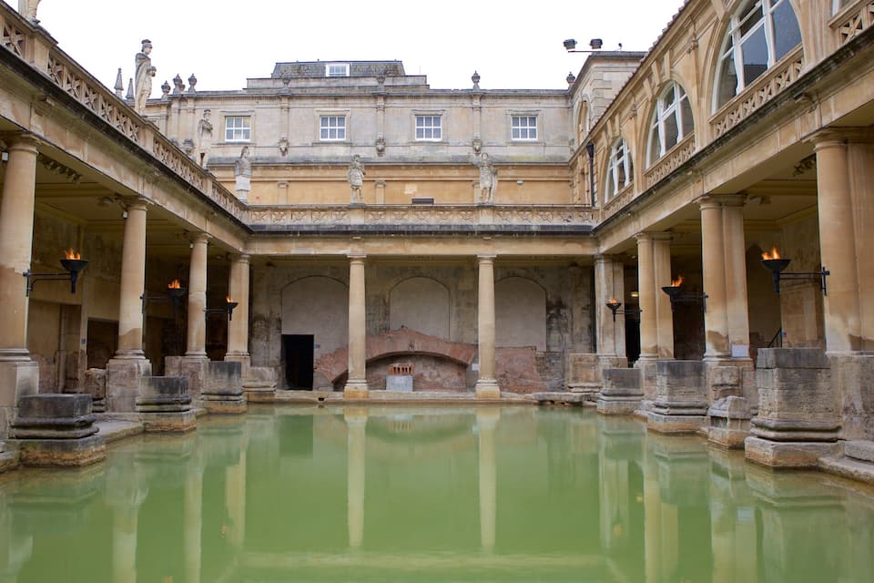 A historic courtyard with a central fountain, surrounded by classical architecture and columns.