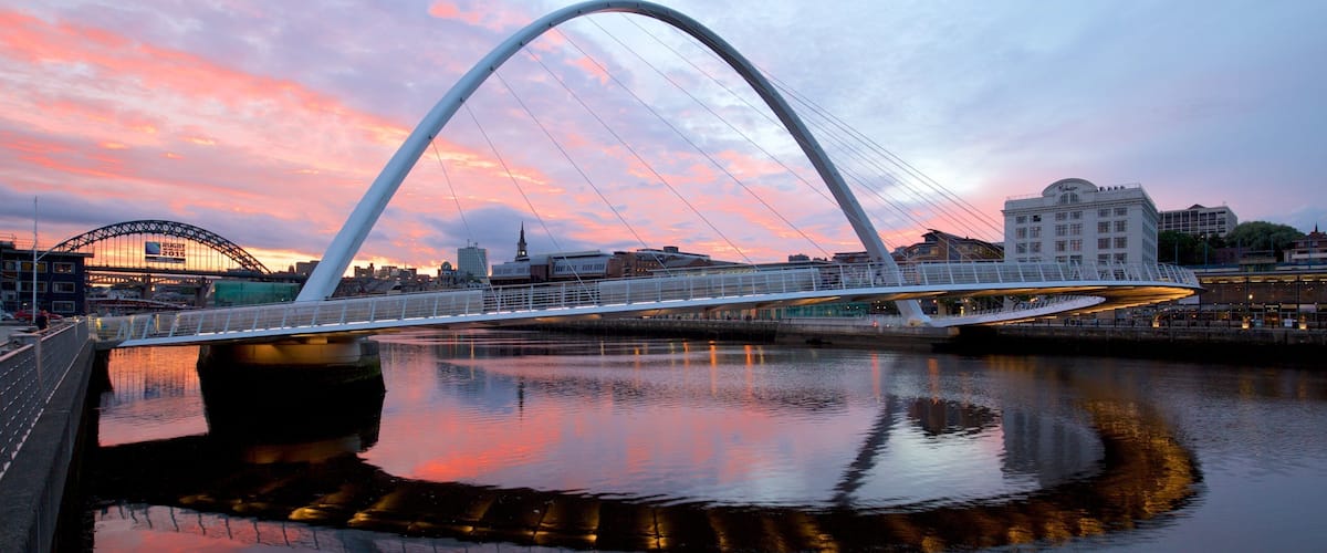 Gateshead Millennium Bridge showing a city, a sunset and a river or creek