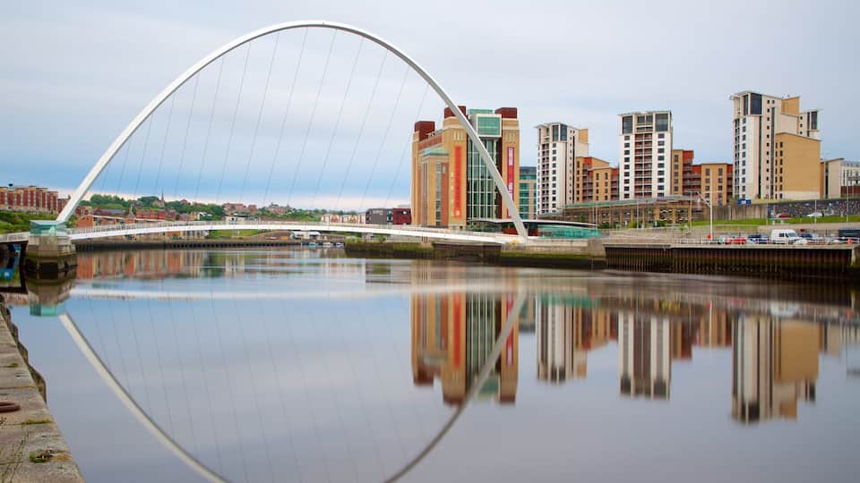 A modern bridge over a calm river, reflecting the surrounding cityscape and buildings.