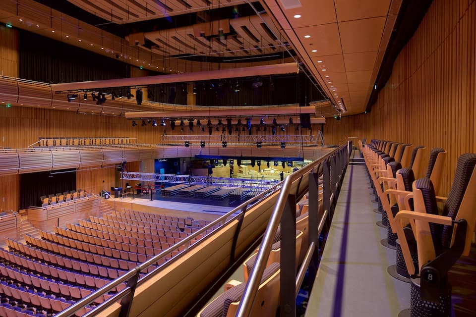 A large indoor auditorium with tiered seating and a stage.