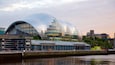A modern glass dome building with a waterfront view.