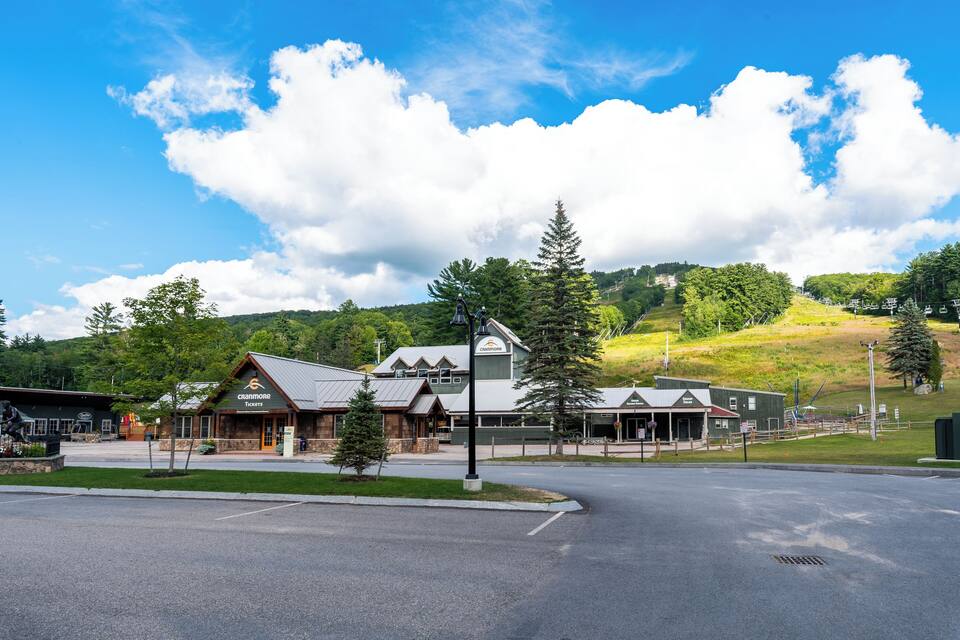 A building with a sign that reads "Cranmore Tickets" and a parking lot in front.