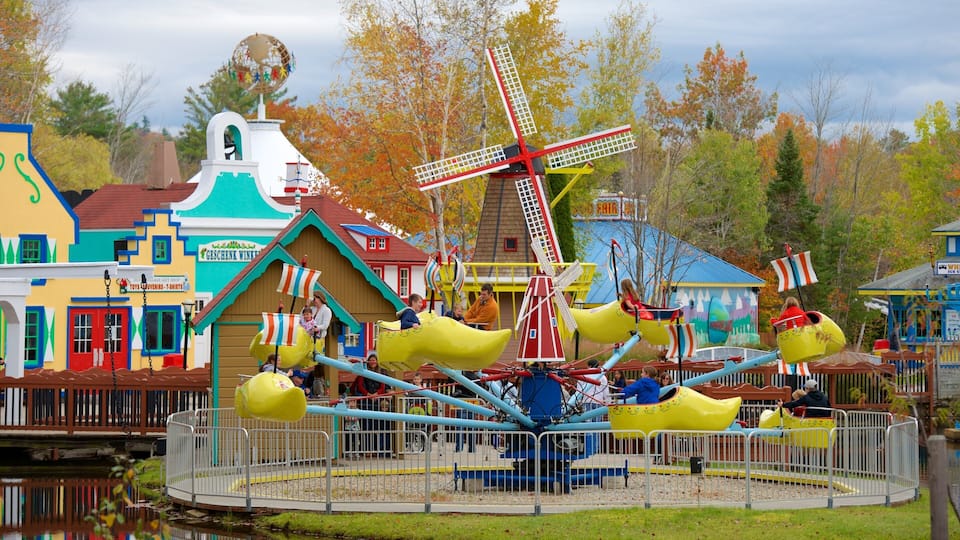 A colorful amusement park with a windmill, yellow boats, and a Dutch-themed building.
