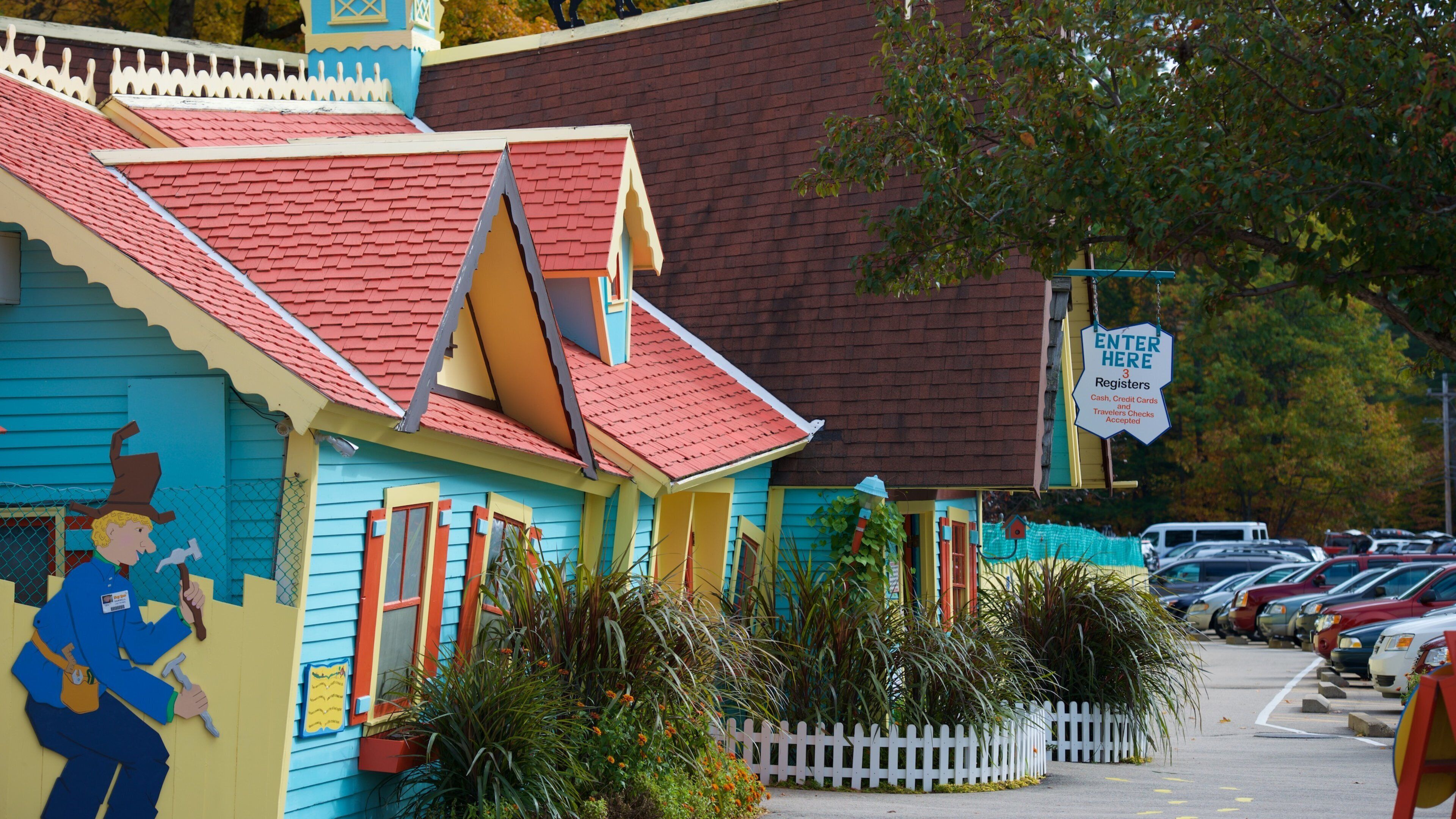 A colorful building with a red roof and a sign that says "ENTER HERE 3 Registers Cash, Credit Cards and Travelers Checks Accepted".