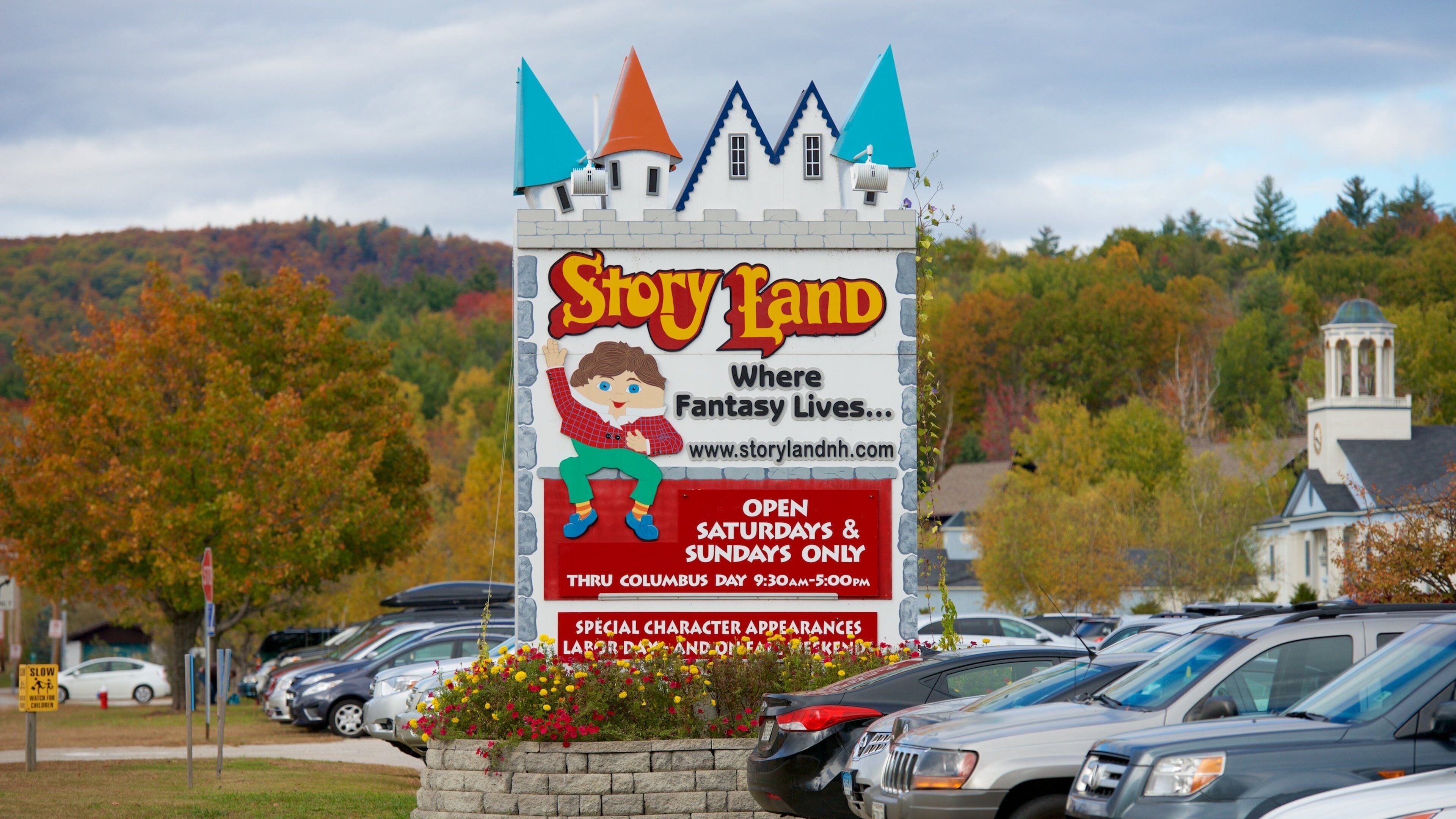 A Story Land sign with a castle design, advertising special character appearances and operating hours.