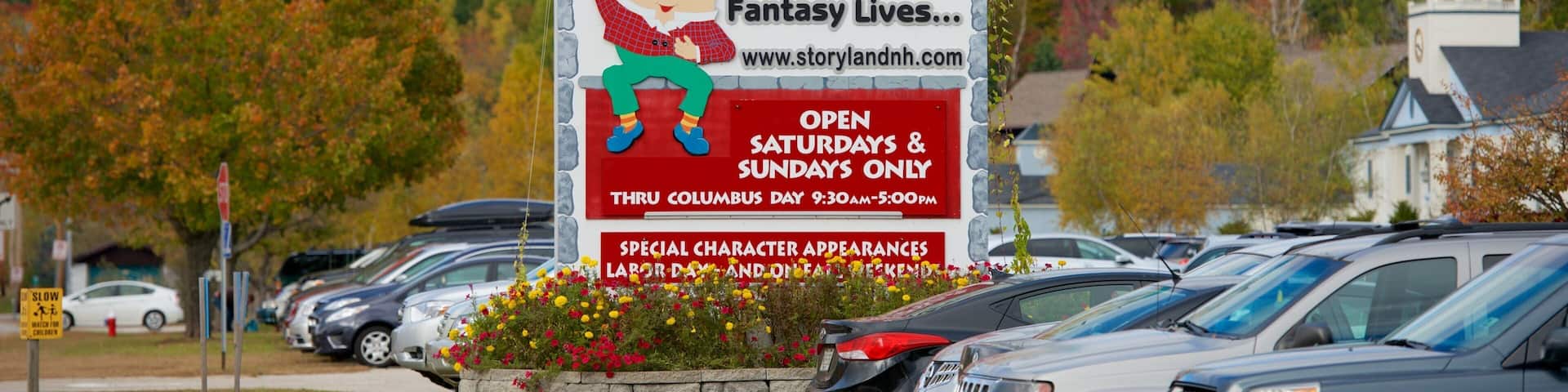A Story Land sign with a castle design, advertising special character appearances and operating hours.