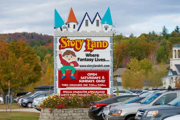 Letrero de Story Land con diseño de castillo, anunciando apariciones especiales de personajes y horarios de atención.