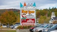 A Story Land sign with a castle design, advertising special character appearances and operating hours.