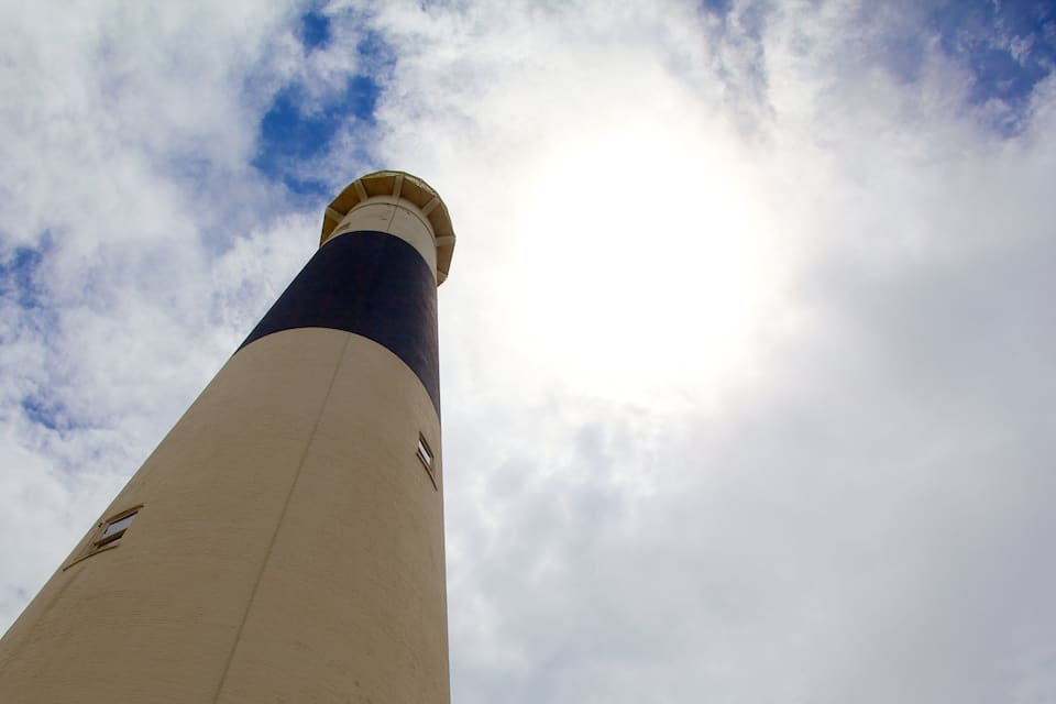 A lighthouse against a partly cloudy sky.