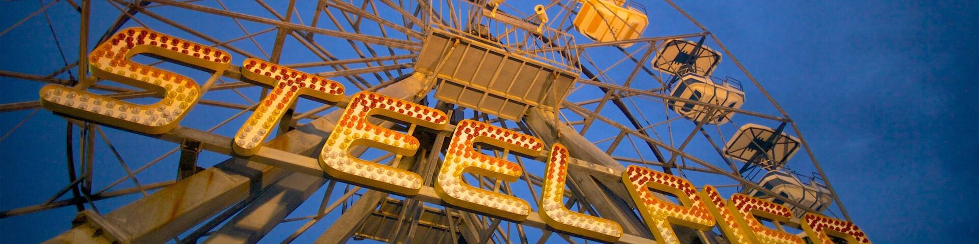 A Ferris wheel with illuminated 'STEEL CITY' letters.