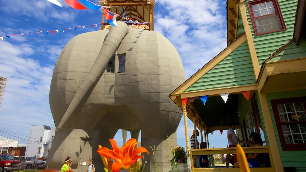 A large, spherical structure with a window, surrounded by colorful flags and a building with a green roof.