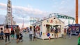 A bustling amusement park with rides like 'KRAZY BALL' and 'PRIZE CHALLENGE'.