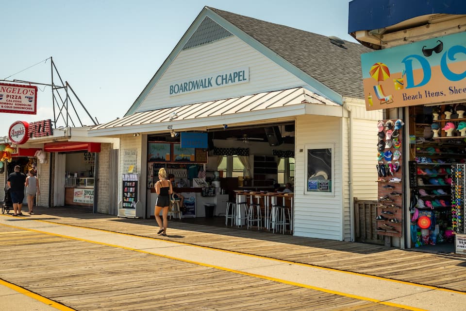 Un paseo marítimo con tiendas, que incluye una capilla, una pizzería y una tienda de recuerdos.