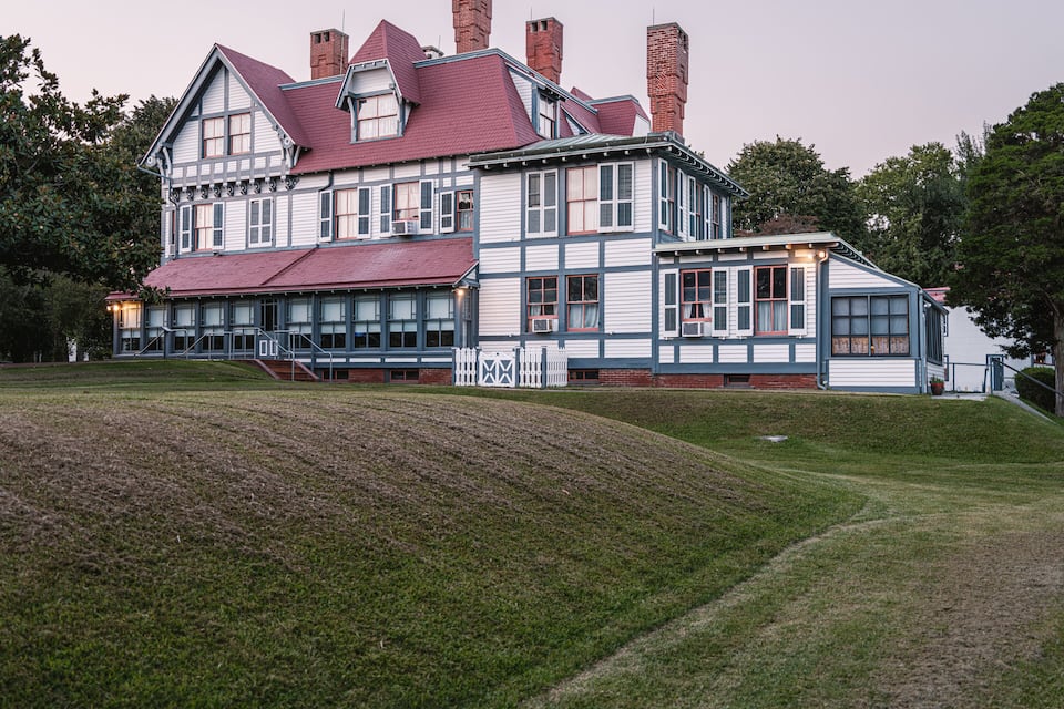 Une grande maison historique, dotée d’un toit rouge et de nombreuses cheminées.