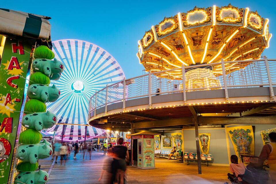 Una noria y un carrusel en un parque de atracciones.
