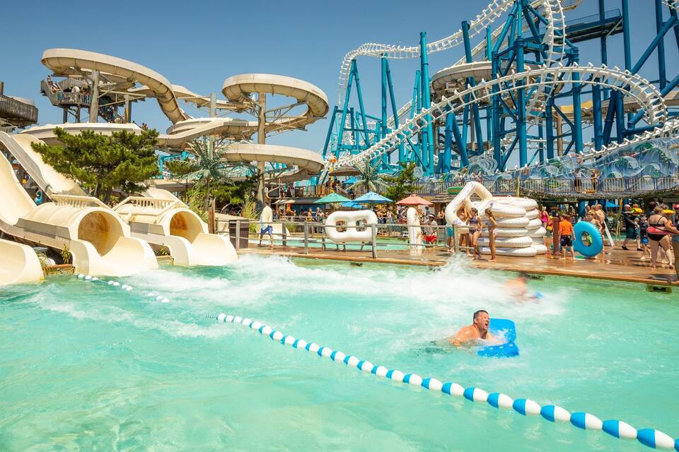 A water park with multiple water slides and a large roller coaster.