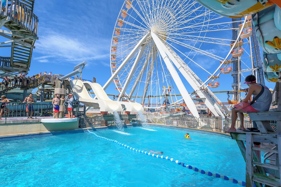 A swimming pool with a Ferris wheel in the background.