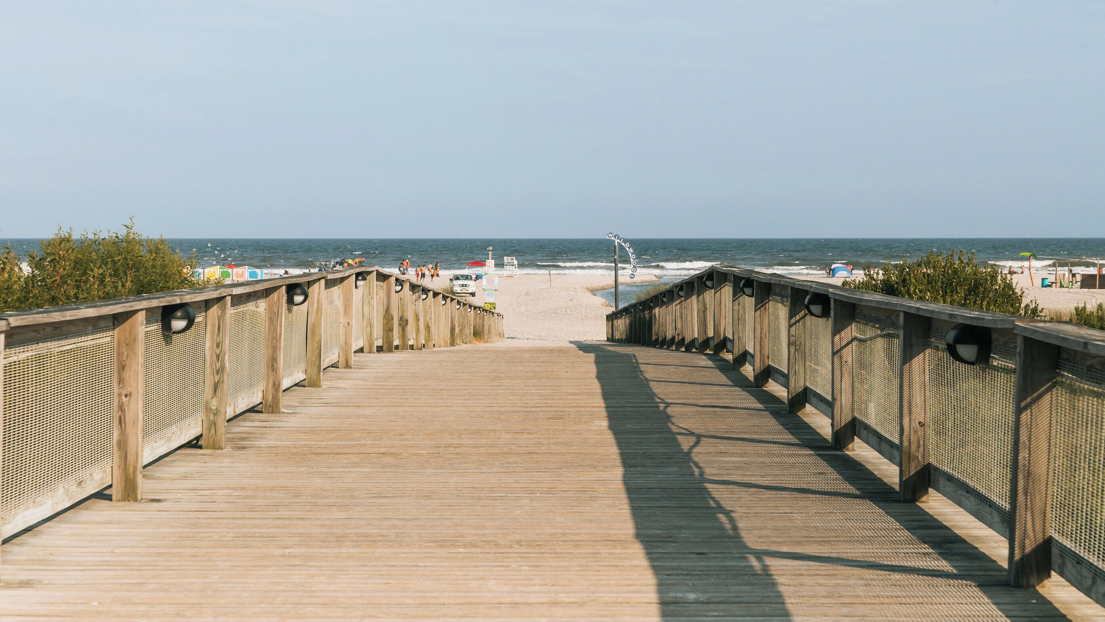 Stroll along the wooden walkway leading to Wildwood Beach in Wildwood Crest, New Jersey on a sunny day