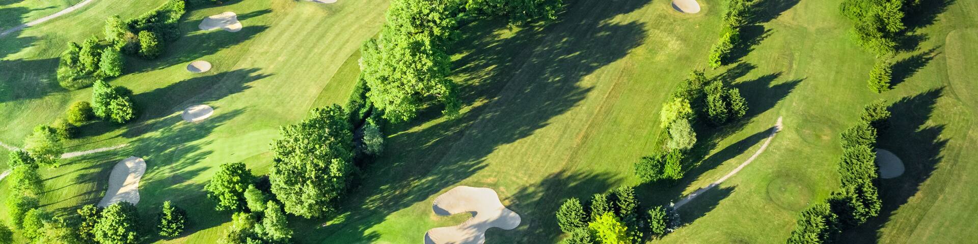 Drone view of a beautiful golf course at sunset with shadows and shapes