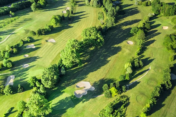 Drone view of a beautiful golf course at sunset with shadows and shapes