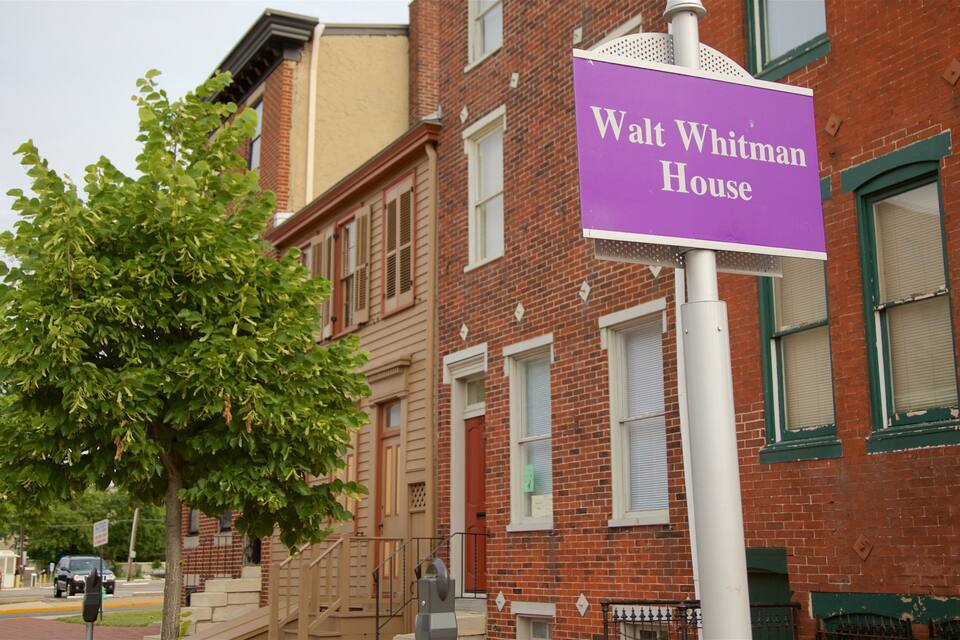 Une rue avec une plaque indiquant «
Maison de Walt Whitman
».