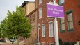 Calle con un letrero que indica 'Walt Whitman House'.