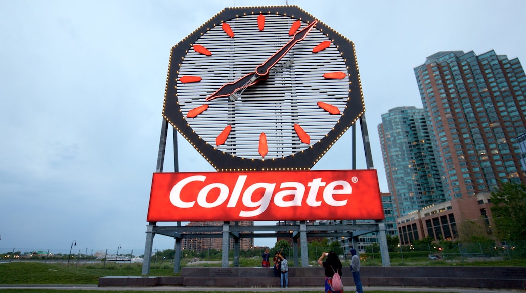 Colgate Clock featuring signage and a city as well as a small group of people