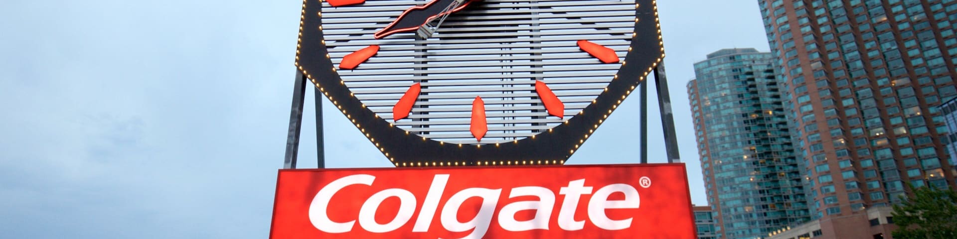 Reloj Colgate ofreciendo señalización y una ciudad y también un pequeño grupo de personas
