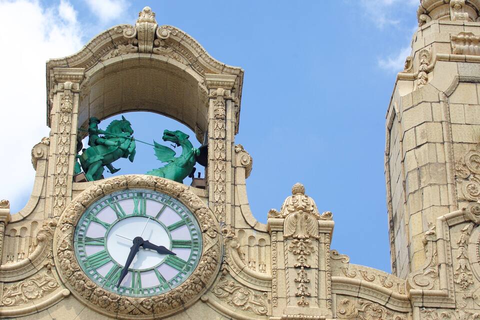 A clock tower with ornate carvings and statues.