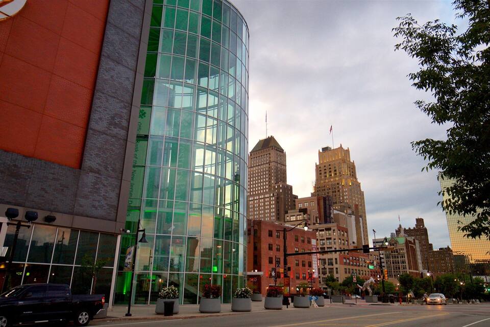 A modern glass building with a 'VIP EAST' sign, surrounded by urban architecture and a clear sky.