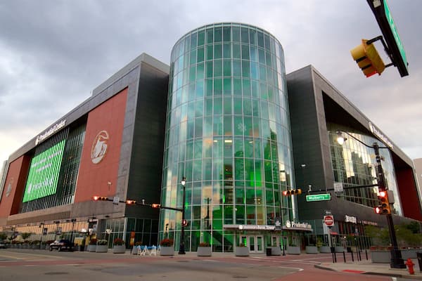 A modern building with a curved glass facade, a prominent logo on the side, and a street sign indicating Mulberry St.