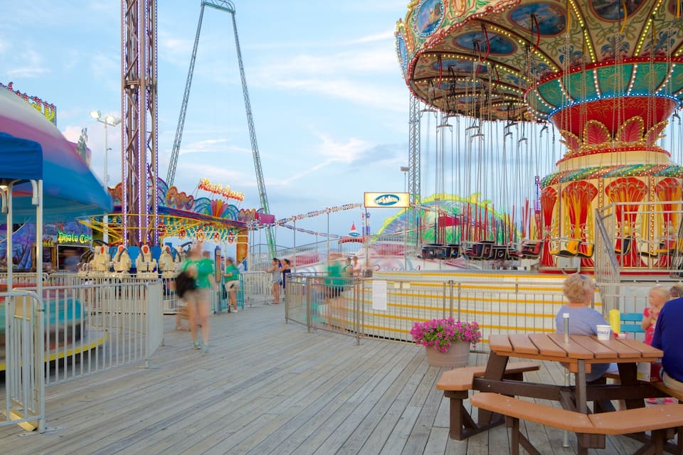 A wooden boardwalk with a carousel and amusement rides.
