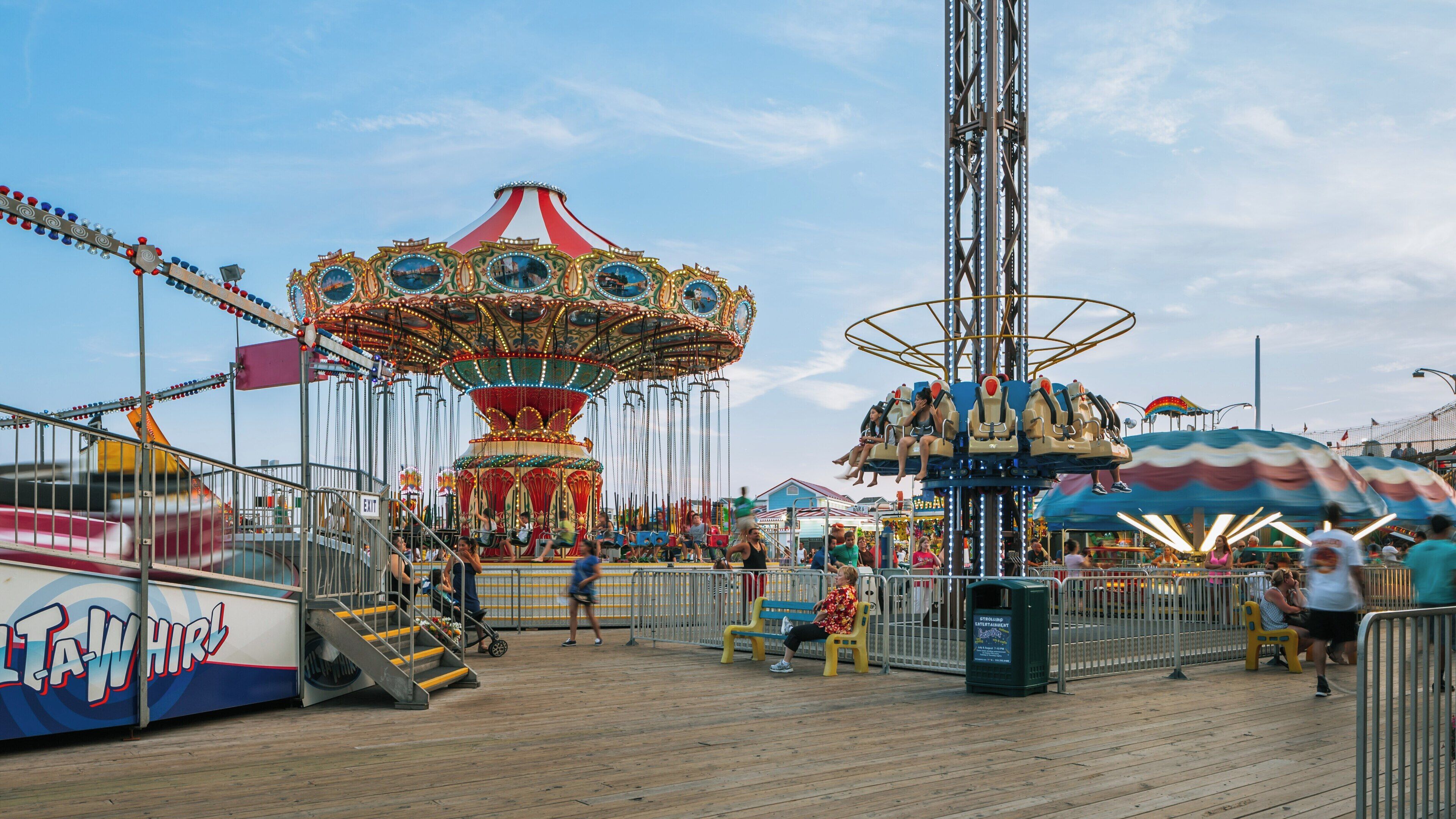 Carnival attractions attract families and thrill-seekers at Casino Pier in Seaside Heights, New Jersey under a clear sky