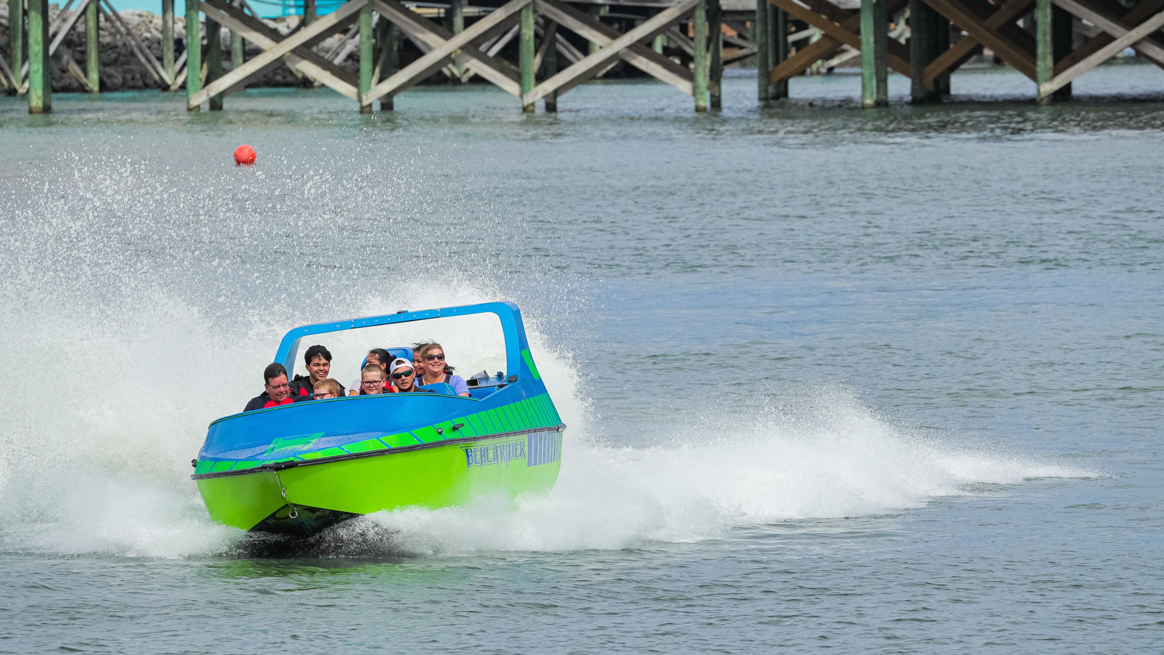 Broadway at the Beach featuring boating and a lake or waterhole as well as a small group of people