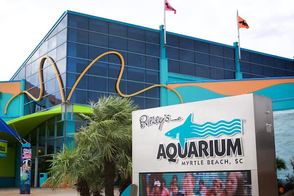 En moderne akvariumsbygning med et stort skilt, der siger "Ripley's Aquarium Myrtle Beach, SC".