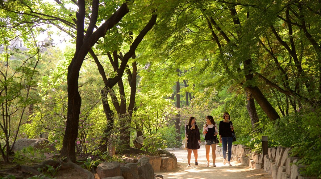Deoksugung Palace featuring a garden as well as a small group of people