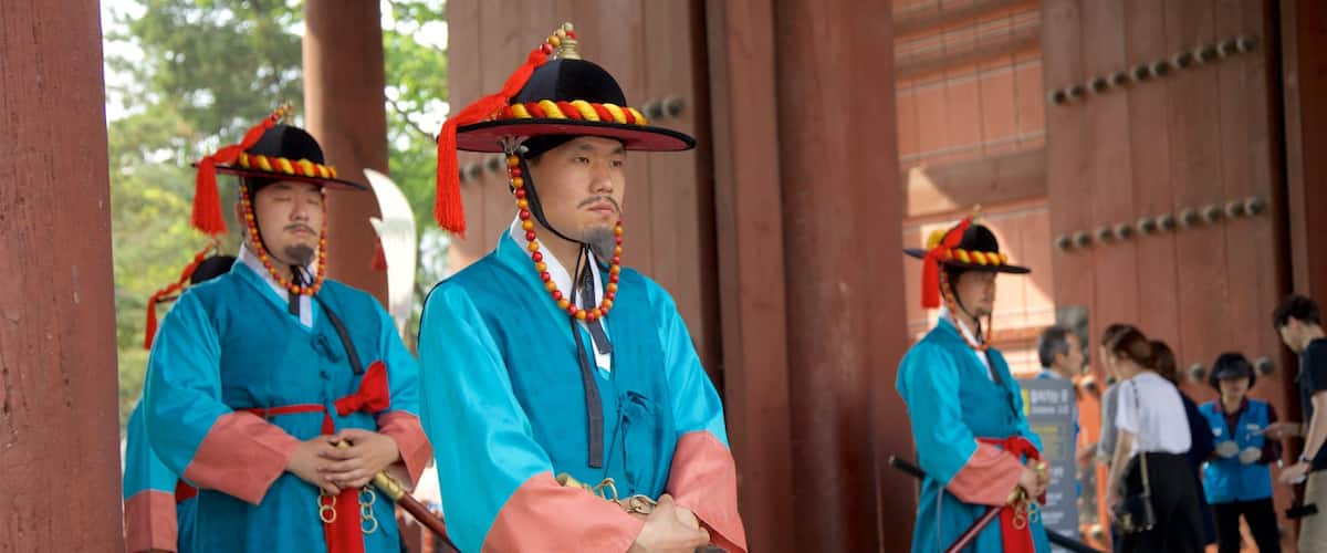Deoksugung Palace featuring performance art as well as a small group of people