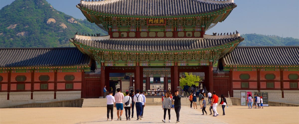 Gyeongbok Palace featuring heritage architecture and a square or plaza as well as a small group of people