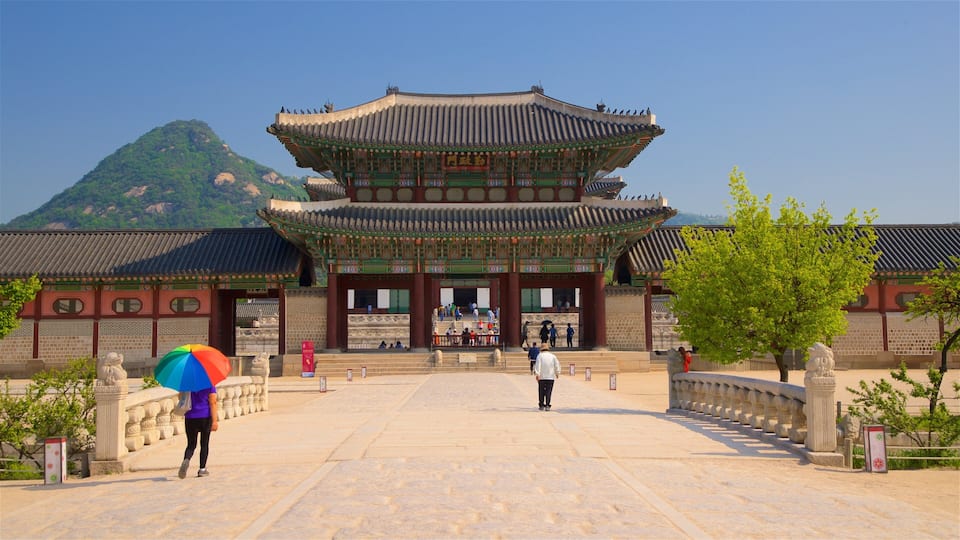 Gyeongbok Palace showing a square or plaza and heritage architecture as well as a small group of people