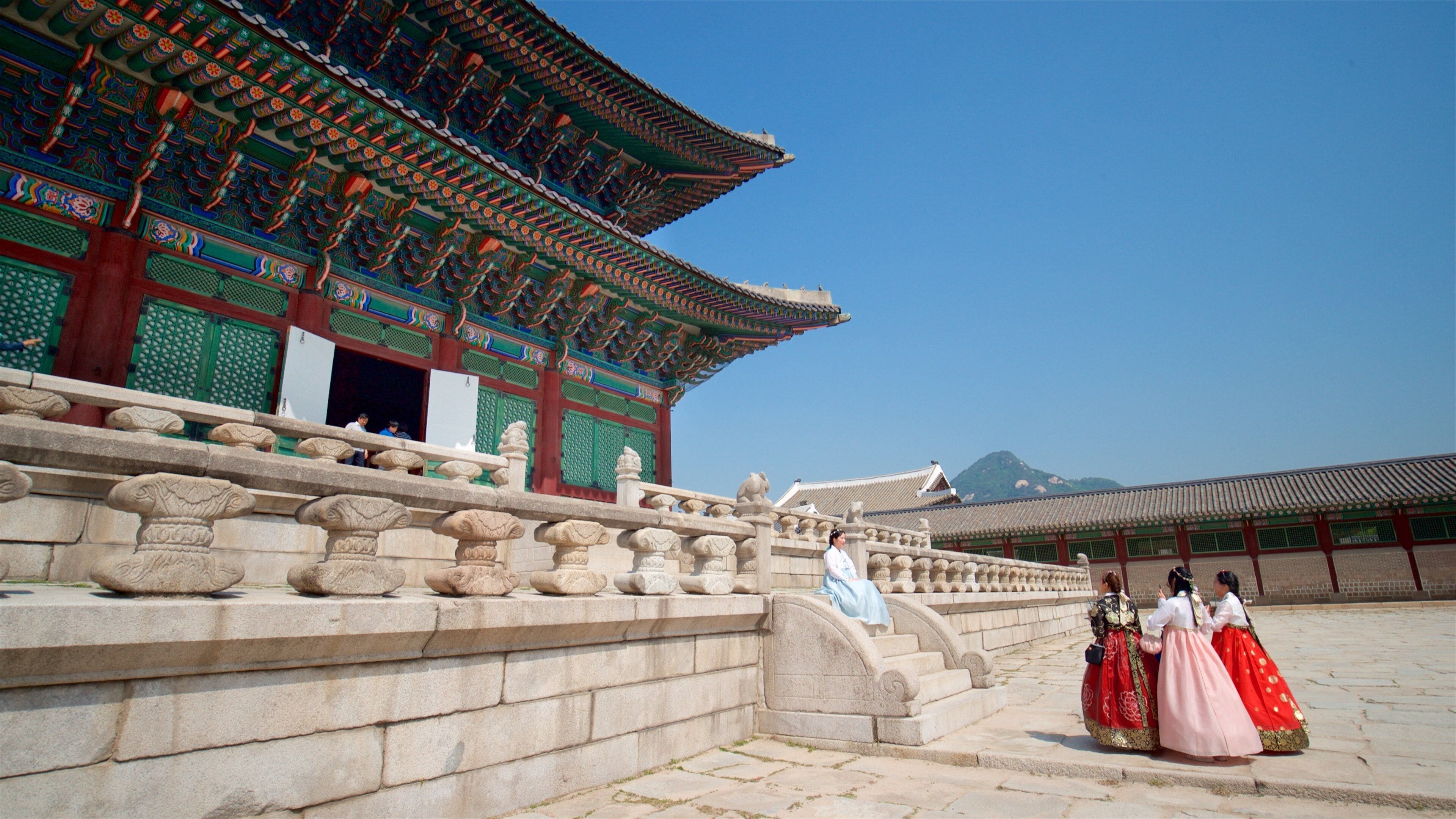 Gyeongbok Palace showing heritage elements and a square or plaza as well as a small group of people